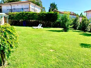 een tuin met een witte bank in het gras bij Apartamento El Pedregal BAJO con jardin in Noja