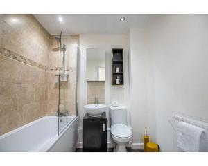a bathroom with a toilet and a tub and a sink at No 2 Mansfield in Mansfield