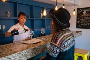 Una donna che versa un bicchiere di vino a un uomo di Tariq Boutique a Cuzco