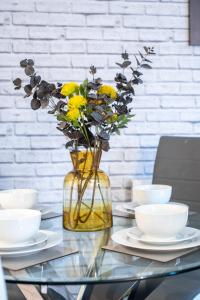 a vase filled with yellow flowers on a glass table at No 2 Mansfield in Mansfield