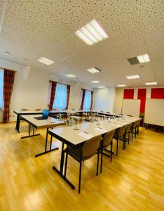 ein Klassenzimmer mit Tischen und Stühlen in einem Raum in der Unterkunft Landhotel Solmser Hof in Echzell