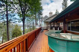 a deck with a view of the mountains on a house at Knott Lakeview in Bass Lake