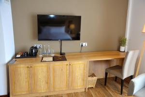 a wooden desk with a television on a wall at Belmont Boutique Hotel Negombo- Free Airport Shuttle Service in Negombo
