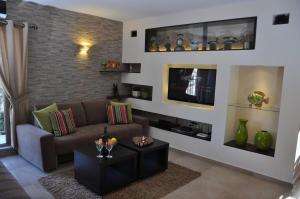 a living room with a couch and a tv at Mory's Place - Luxurious Holiday Apartment in Arad