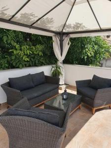 a patio with two couches and a table and chairs at Old Town Baska in Baška