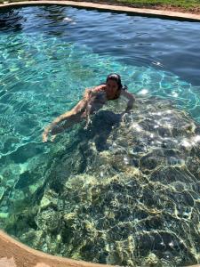 a woman floating in a pool of water at Rancho do Paioleiro - Suites in São Bento do Sapucaí