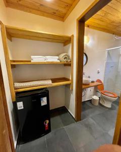 a small bathroom with a sink and a toilet at Rancho do Paioleiro - Suites in São Bento do Sapucaí