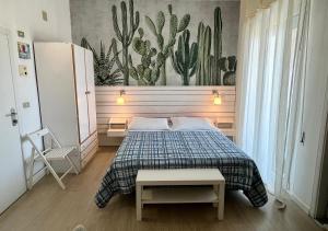 a bedroom with a bed and a mural of cactus at B&B Everest Bar Ristorantino in Gabicce Mare