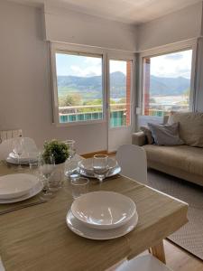 uma sala de estar com uma mesa com pratos e copos de vinho em Mundaka best views house em Mundaka