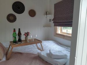 a bedroom with a table with bottles and glasses on a bed at Doris in Wedmore