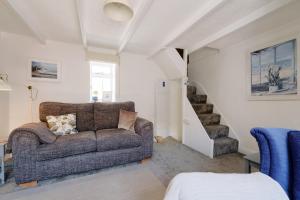 a living room with a couch and a staircase at Finest Retreats - Coral Cottage in Porthleven