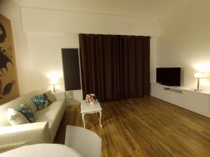a living room with a couch and a television at Appartement de standing dans le Golf International de La Baule in Saint-André-des-Eaux