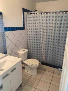 a bathroom with a toilet and a shower curtain at Beautiful studio Jordan Village - 5min from AUC School of Medicine in Cul de Sac