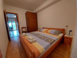 a bedroom with a large bed with towels on it at Apartment Pezić in Krk