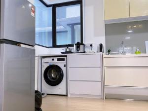 a kitchen with a washing machine and a sink at D'sara Sentral Sovo in Sungai Buluh