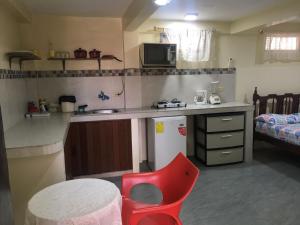 a small kitchen with a red chair and a table at Casa Violeta in Guayaquil