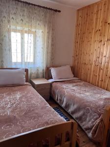 1 dormitorio con 2 camas y ventana en Guest House Sabriu, en Rabdisht