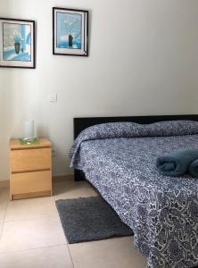 - une chambre avec un lit, une table de chevet et 2 photos dans l'établissement Apartment la Puntilla del Mar, à Las Palmas de Gran Canaria