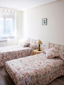 a bedroom with two beds and a window at VEGA DEL CARMEN in Teruel