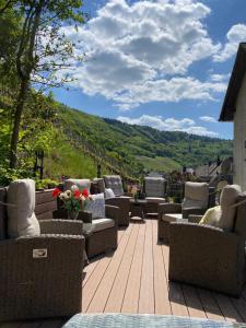 a deck with chairs and couches on top of a mountain at Ferienpension bei Stenze in Senheim