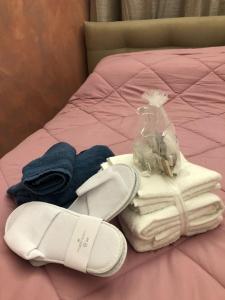 a pile of towels and shoes on a bed at Gioiellino a Trieste in Trieste
