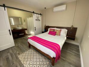 a bedroom with a large bed with pink pillows at Cerrado in El Porvenir