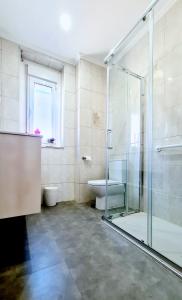 a bathroom with a glass shower and a toilet at VEGA DEL CARMEN in Teruel