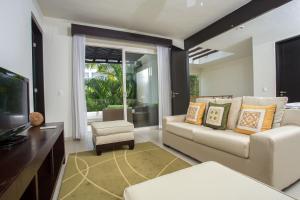 a living room with a couch and a tv at Marival Distinct Luxury Residences & World Spa All Inclusive in Nuevo Vallarta