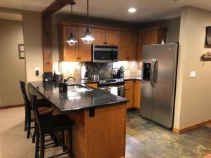 a kitchen with a stainless steel refrigerator and a counter at Penthouse Mountain Haven with Community Spa Room in Kellogg