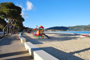 a beach with a playground on the beach at Appartamenti Olivo - 100 mt dal mare con aria condizionata in Marina di Campo