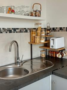 a kitchen counter with a sink and a microwave at Un Nid Douillet en bord de plage !! in Lucciana