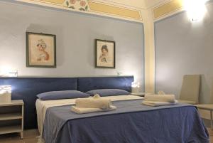 a bedroom with a blue bed with two pillows on it at Suite Apartment Castello in Volterra