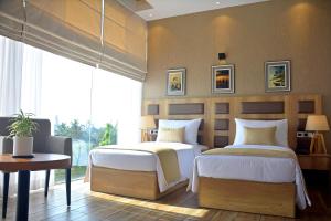 a bedroom with two beds and a table and a window at Belmont Boutique Hotel Negombo- Free Airport Shuttle Service in Negombo +31 photos