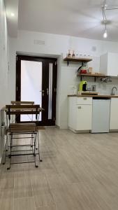 a room with a table and a kitchen with a counter at La Pelliccia in Bari