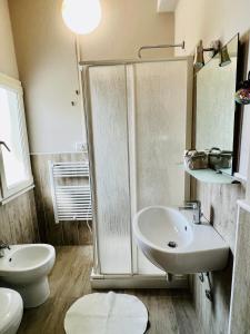 een badkamer met een douche, een wastafel en een toilet bij B&B Everest Bar Ristorantino in Gabicce Mare