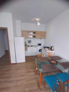 eine Küche und ein Esszimmer mit einem Tisch und einem Kühlschrank in der Unterkunft THE CENTER Apartments Comfort in Sandanski