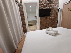 a bedroom with a white bed and a brick wall at Hôtel Bella Vista in Porto Ota