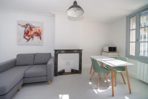 a living room with a couch and a table at Le Triompha Montpellier Proche Arc de Triomphe in Montpellier