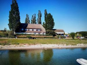 a house sitting on the shore of a body of water at Ferienwohnung Soling in Alt Reddevitz