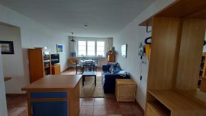 a living room with a blue couch and a table at Ferienwohnung Soling in Alt Reddevitz