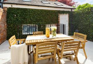 a wooden table and chairs on a patio at The Racecourse Garden Collection in Chester