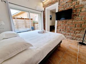 a bedroom with a large bed and a brick wall at Hôtel Bella Vista in Porto Ota