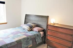 1 cama con cabecero de madera junto a un tocador en Hood River Family Vacation Home en Hood River