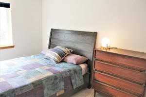 a bed with a wooden headboard next to a dresser at Hood River Family Vacation Home in Hood River