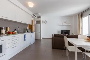 uma cozinha e sala de estar com um sofá e uma mesa em Apartamentos Cornellalux 2 em Cornellà de Llobregat