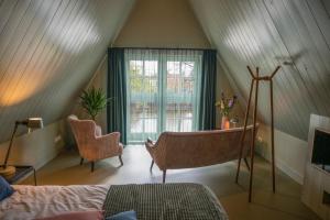a attic room with a bed and a window at B&B Turfkade9 in Franeker