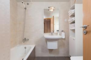 uma casa de banho com um lavatório, um espelho e uma banheira em Apartamentos Cornellalux 2 em Cornellà de Llobregat mais 65 fotografias