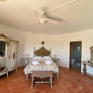 Schlafzimmer mit einem Bett und einem Deckenventilator in der Unterkunft Casa do Milho in Carvoeiro