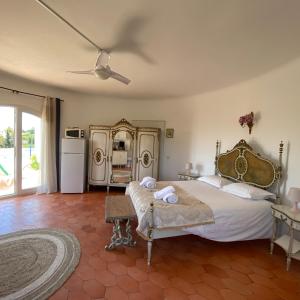 ein Schlafzimmer mit einem großen Bett und einem Kühlschrank in der Unterkunft Casa do Milho in Carvoeiro