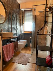 a bathroom with a toilet and a glass shower at WellHome in Marina di Montemarciano